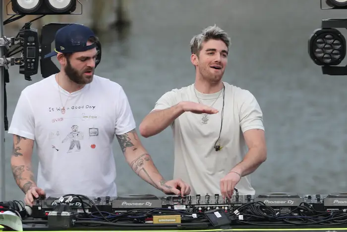 Chainsmokers members Alex Pall and Andrew Taggart are DJing on a stage.